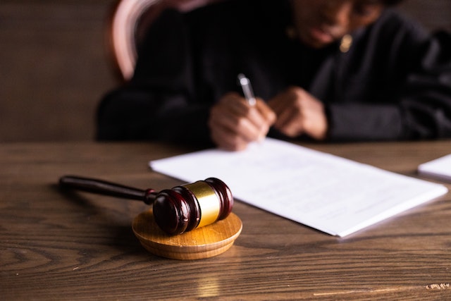 a judge signing papers behind a gavel